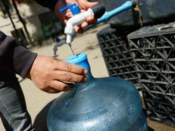Persona llenando un bidón tras corte de agua