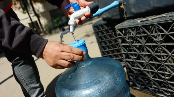 Persona llenando un bidón tras corte de agua