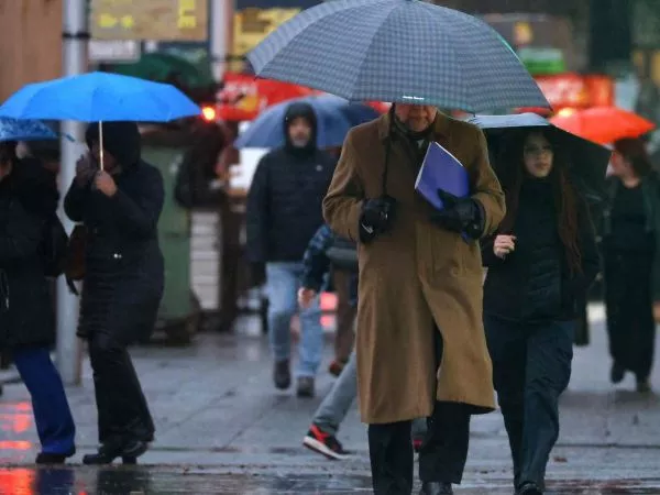 Personas con paraguas bajo la lluvia en Santiago