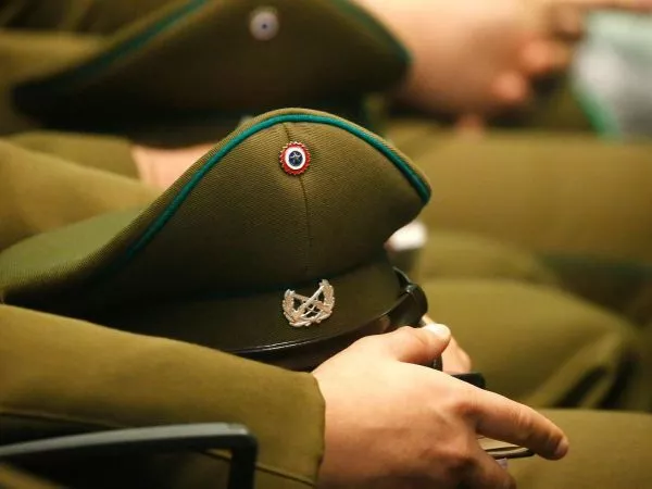 Carabinero sentado sosteniendo su gorra