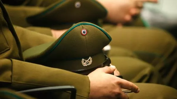 Carabinero sentado sosteniendo su gorra
