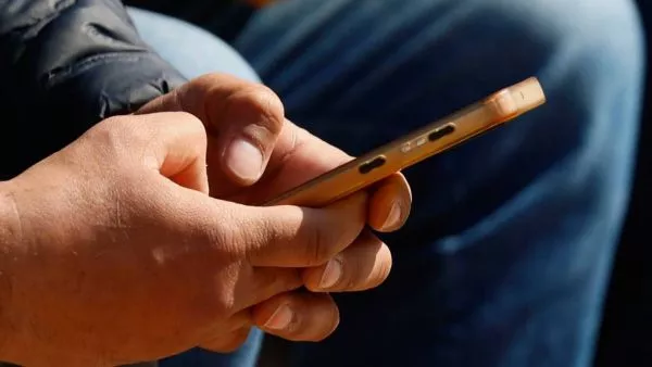 Persona con teléfono celular en la mano