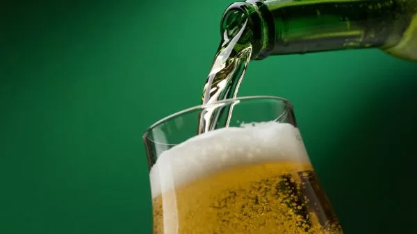 Persona sirviendo un vaso de cerveza