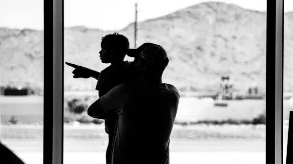 Niño y adulto en un aeropuerto en blanco y negro