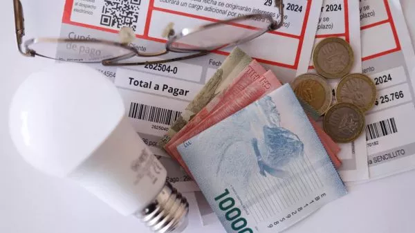 Cuenta de la luz, una ampolleta y billetes de distinta denominación