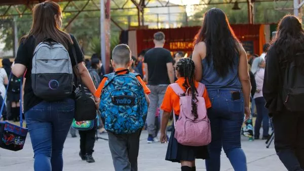 Estudiantes con mochilas entrando a clases