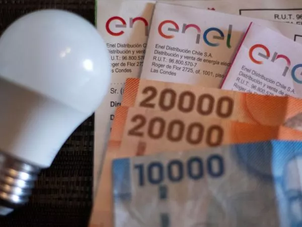Ampolleta, boletas de la cuenta de la luz y billetes de distinta denominación