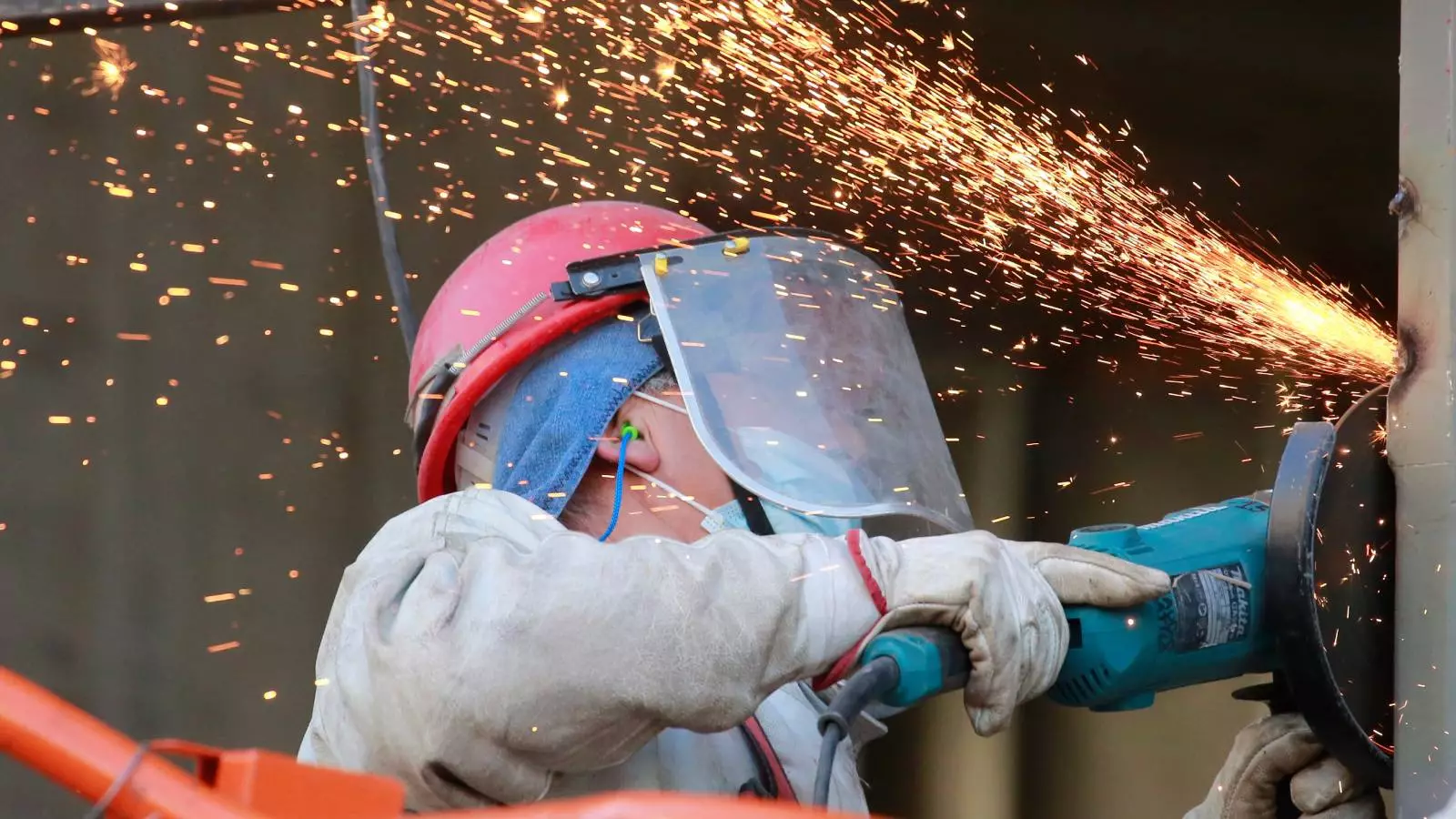 Persona trabajando con un esmeril en altura