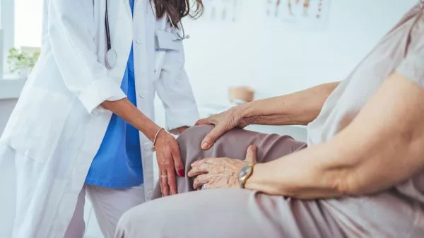 Adulta mayor siendo atendida por osteoartritis en su rodilla