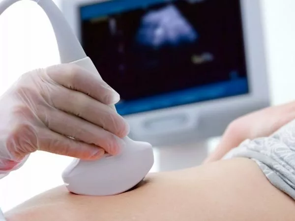 Especialista realizando un ultrasonido a una mujer embarazada