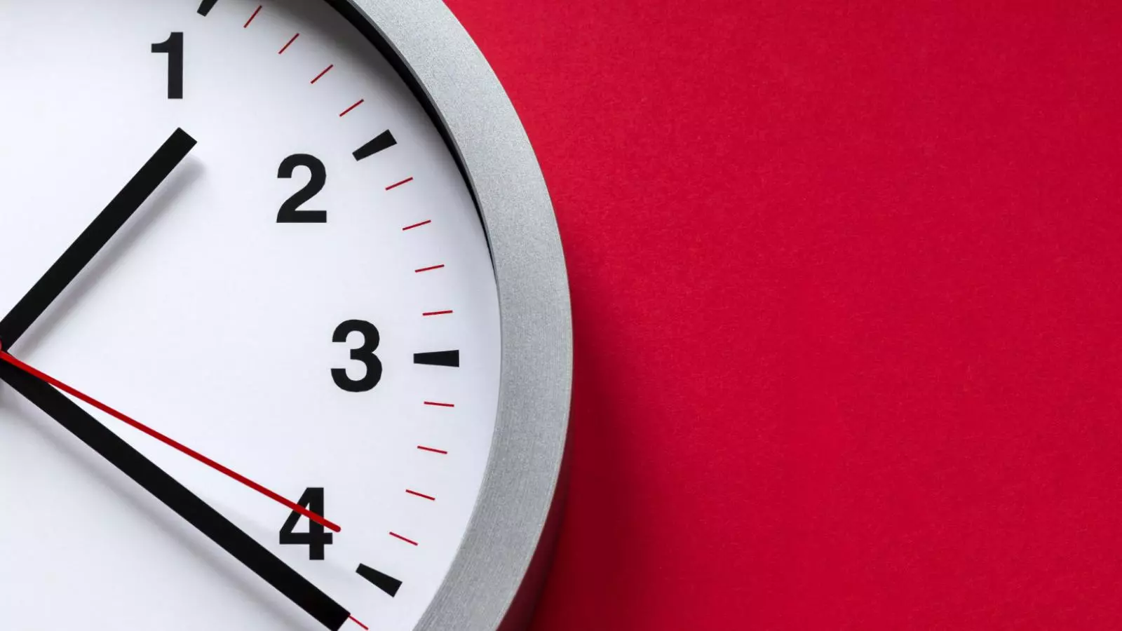 Reloj análogo sobre un fondo rojo