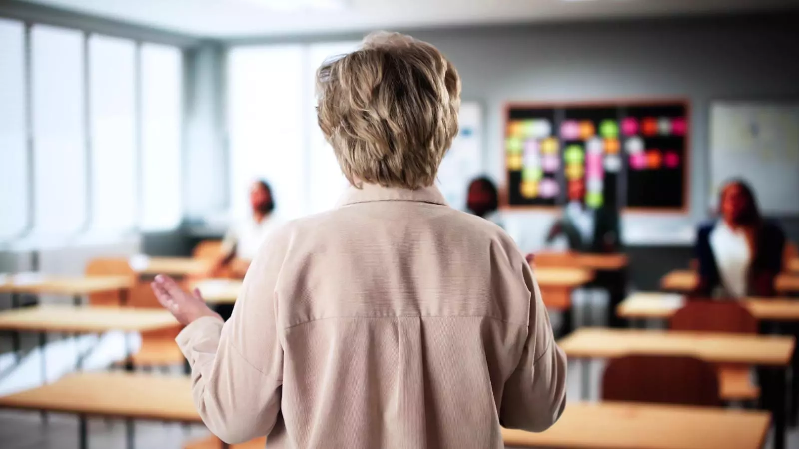 Profesora mayor en una sala de clases con pocos alumnos
