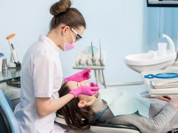 Odontóloga atendiendo a una paciente en una consulta dental