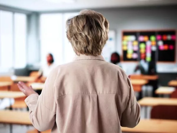 Profesora mayor en una sala de clases con pocos alumnos