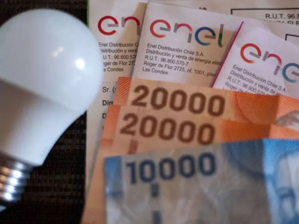 Ampolleta apagada, billetes de distinta denominación y varias boletas de cuentas de la luz de Enel