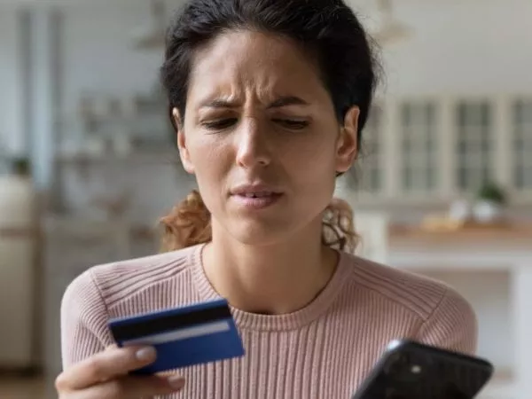 Mujer realizando una compra online con expresión decepcionada